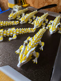 Artikulierte 3D-Drachen in Weiß und Gelb – echte Produktaufnahme